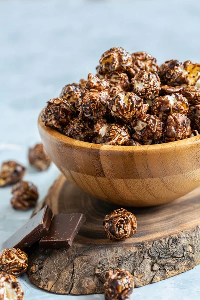 Bowl of chocolate popcorn on the serving board, selective focus.
