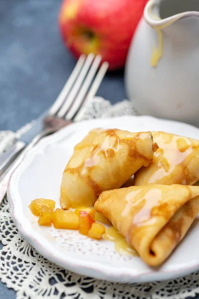 Homemade crepes with apples and caramel sauce.