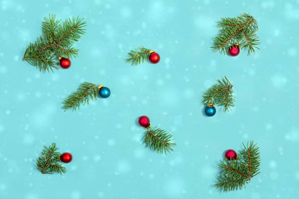 Christmas composition. Fir tree branches and balls on blue background. Christmas, winter, new year concept. Flat lay, top view.