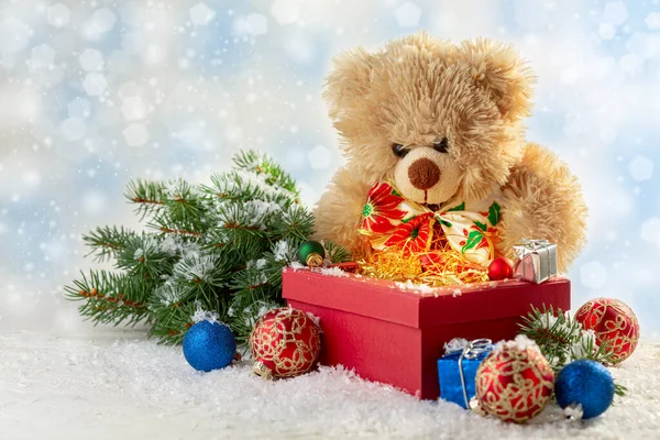 Christmas card with gifts and balloons in a box, fir branches and a toy bear, selective focus. Christmas concept with copy space.