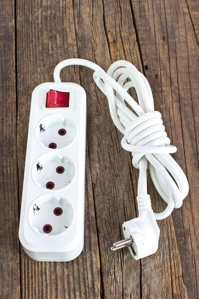 Ahşap arka plan üzerinde elektrik fişi güç kablosu