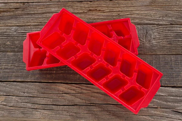 Contenitore di ghiaccio in plastica su fondo di legno Foto Stock Royalty Free