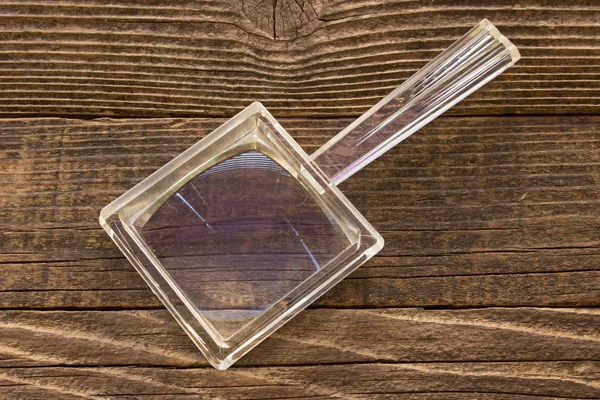 Förstoringsglas på trä bakgrund — Stockfoto