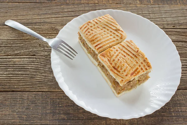 Яблочный пирог два ломтика торта на тарелке за деревянным столом — стоковое фото