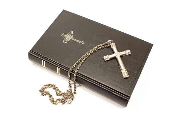 Heilige Bibel mit silbernem Kreuz auf weißem Hintergrund — Stockfoto