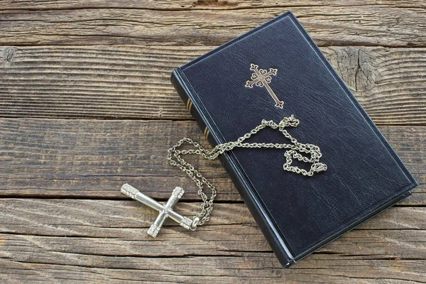Svatá bible se stříbrným křížem na dřevěném pozadí — Stock fotografie
