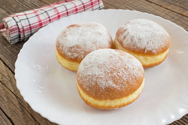 Berliner pączki w talerzu na drewnianym stole — Zdjęcie stockowe