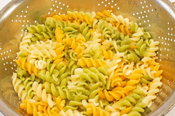 Готовые Fusilli триколор макароны в дренажный фильтр близко — стоковое фото