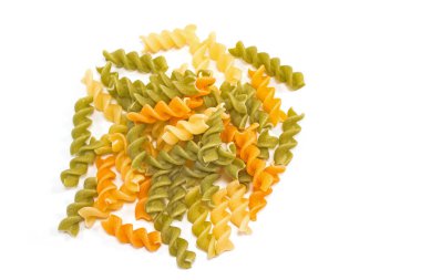 Fusilli üç renkli çiğ makarna yığını beyaza izole edilmiş.        