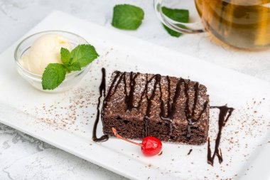Beyaz tabakta dondurmalı Brownie tatlısı.