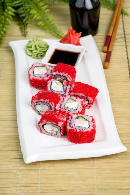 Beyaz bir tabakta soslu Kaliforniya suşisi. Yakın çekim.