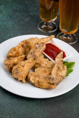 Beyaz tabakta soslu tavuk kanadı. Yakın çekim.