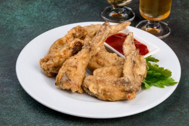 Beyaz tabakta soslu tavuk kanadı. Yakın çekim.