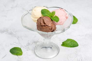 Şeffaf bir bardakta üç top dondurma. Yakın çekim.