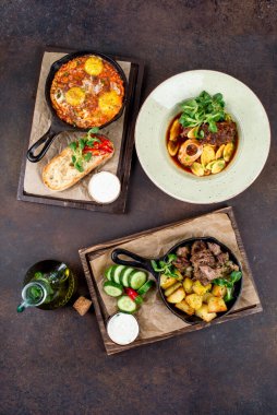 Etli, patatesli, sebzeli, yukarıdan çekilmiş bir sürü tabak.