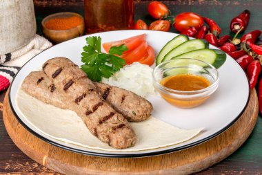 Beyaz bir tabakta sebzeli ızgara kuzu kebabı. Yakın çekim.