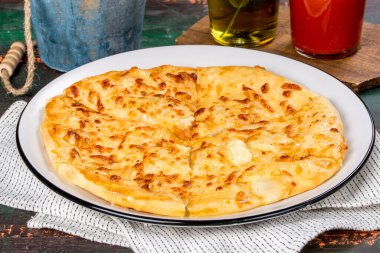 Beyaz tabakta servis edilen, yumurtalı beyaz khachapuri yemeği. Yakın çekim.