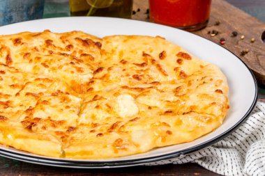 Beyaz tabakta servis edilen, yumurtalı beyaz khachapuri yemeği. Yakın çekim.