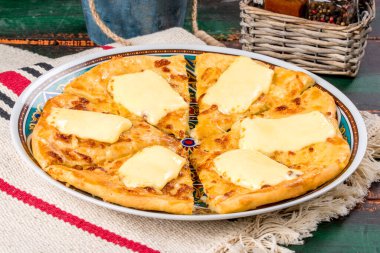 Beyaz tabakta servis edilen, yumurtalı beyaz khachapuri yemeği. Yakın çekim.