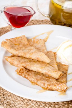 Beyaz tabakta kremalı dondurmalı krep var. Yakın çekim.