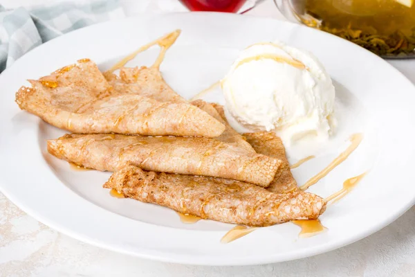 Beyaz tabakta kremalı dondurmalı krep var. Yakın çekim.