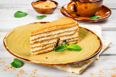 Bir dilim ballı kek. Nane yapraklı güzel bir tabak. Yakın çekim.