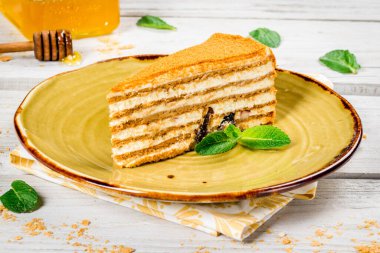 Bir dilim ballı kek. Nane yapraklı güzel bir tabak. Yakın çekim.