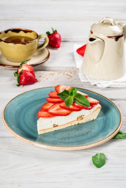 Güzel bir tabakta bir dilim çilekli turta. Yakın çekim.