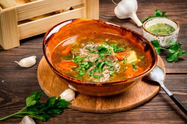 Taze tortilla ve ahşap arka planda güzel bir tabakta otlarla Shurpa. Yakın çekim.