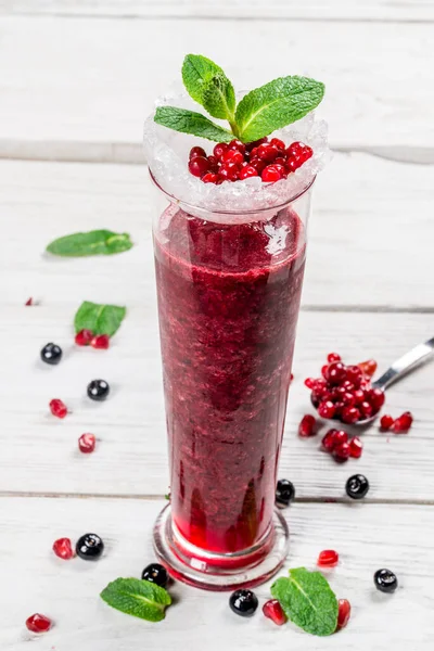 Berry smoothie with mint in a long glass glass. Close-up shot