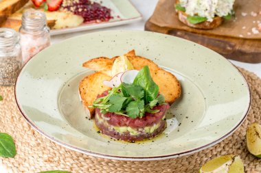 Küçük et parçalarından salam taze bitkilerle yuvarlak bir formda. Yakın çekim.