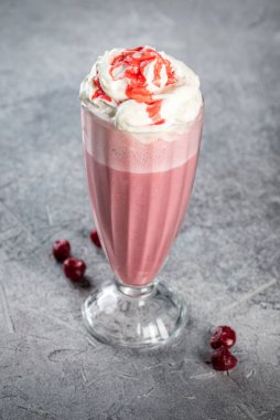 Şeffaf, uzun, cam bardakta vişneli milkshake. Yakın çekim.