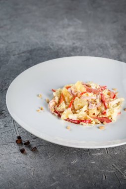 Çam fıstıklı salata, lahana, pastırma, beyaz tabakta biber.