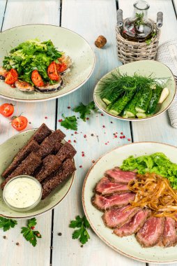 Tuzlu salatalık, kraker, beyaz ahşap arka planda rosto.