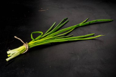 Siyah arka planda bir sürü yeşil soğan. Yakın çekim.