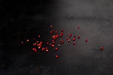 Siyah arkaplana dağılmış farklı türde biberler. Yakın çekim..