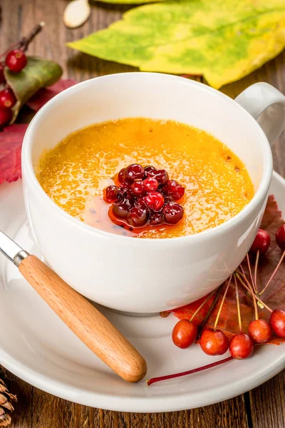 Yellow soup decorated with rowan in a white plate. Shot close up — Stock Image Yellow Soup Decorated Rowan White Plate Shot Close Royalty Free Stock Images