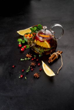 Çay ve böğürtlenli çaydanlık, siyah arka planda yakın plan çekimi.