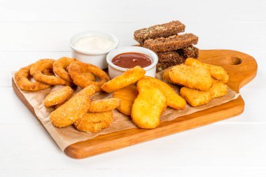 Bira tabağı, kıtır ekmek, tavuk, ahşap bir tahtanın üzerindeki soslar.