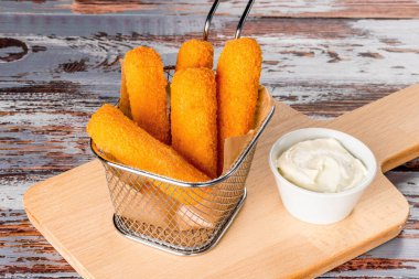 Tahta üzerinde sos olan peynirli çubukların yakın plan çekimi.