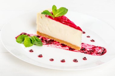 Nane yapraklarıyla süslenmiş reçelli bir parça peynirli kek.