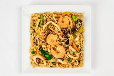 Yakından fileto çekmek için beyaz tabakta deniz mahsullü pilav.