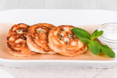 Kızarmış Rus usulü krep tabakta. Arka planda yakın plan çekimleri