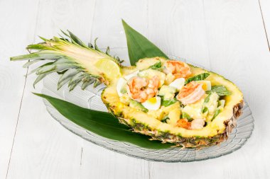 Beyaz ahşap arka planda ananas karides salatası.