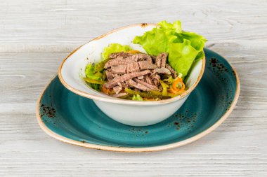 Sığır eti ve turşulu salata arka plandaki menü için yakın plan çekilecek.