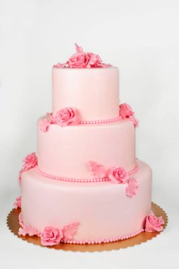 Beyaz üzerine büyük pasta stüdyoda dikey olarak çekiliyor.