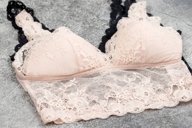 Ahşap bir arka planda kadın iç çamaşırı yakından çekiliyor.