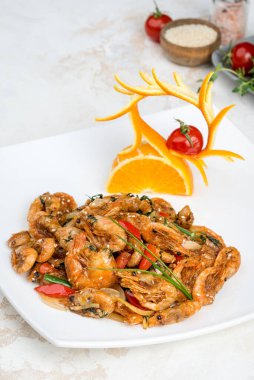 Portakallı beyaz tabakta karides salatası. Yakın çekim.