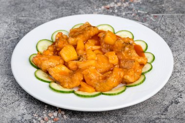 Salatalıkla süslenmiş, beyaz bir tabağa tünemiş turna balığı.