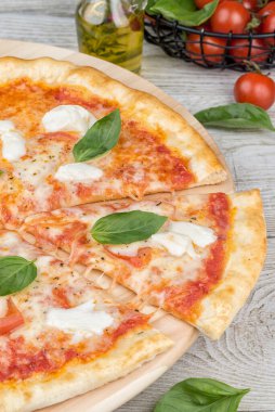 Tahta üzerinde dilimlenmiş pizza margherita. Yakın çekim.